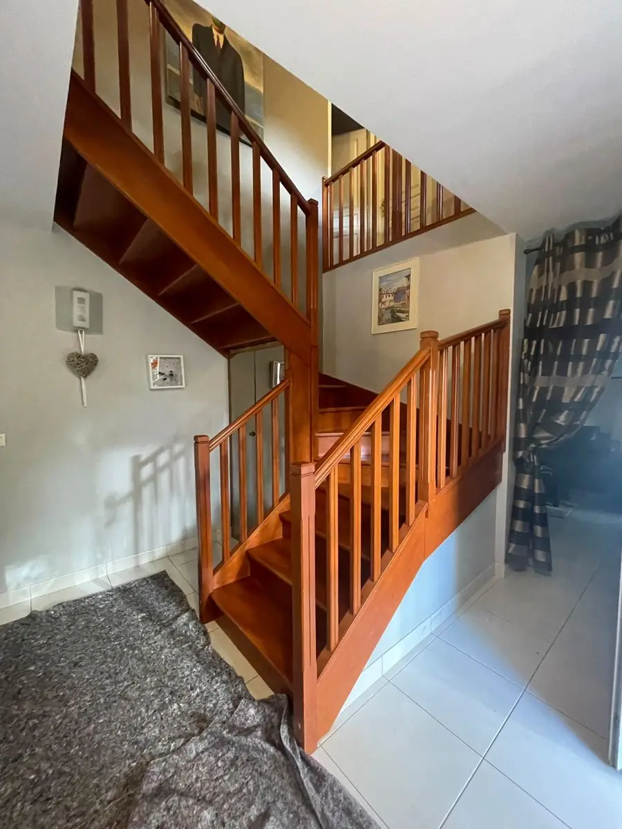 Escalier en bois verni orange avant rénovation